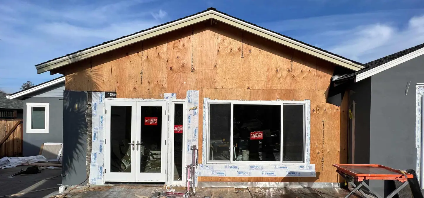 Detached ADU under construction with new siding, windows and a sliding door