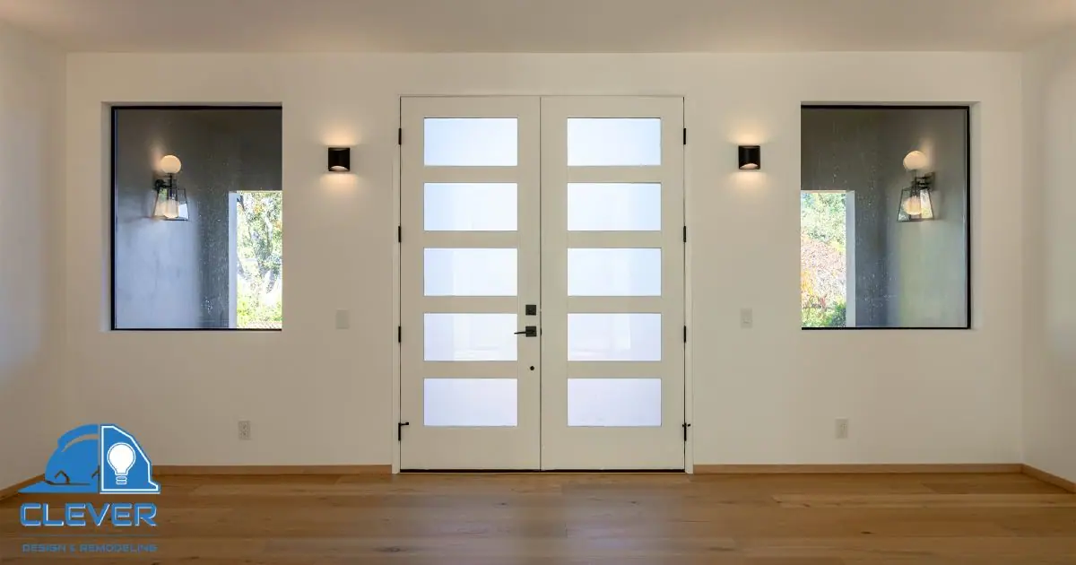 New glass-paneled front doors flanked by modern sconces