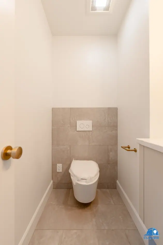 Powder room with wall-mounted fixtures and stone wainscot