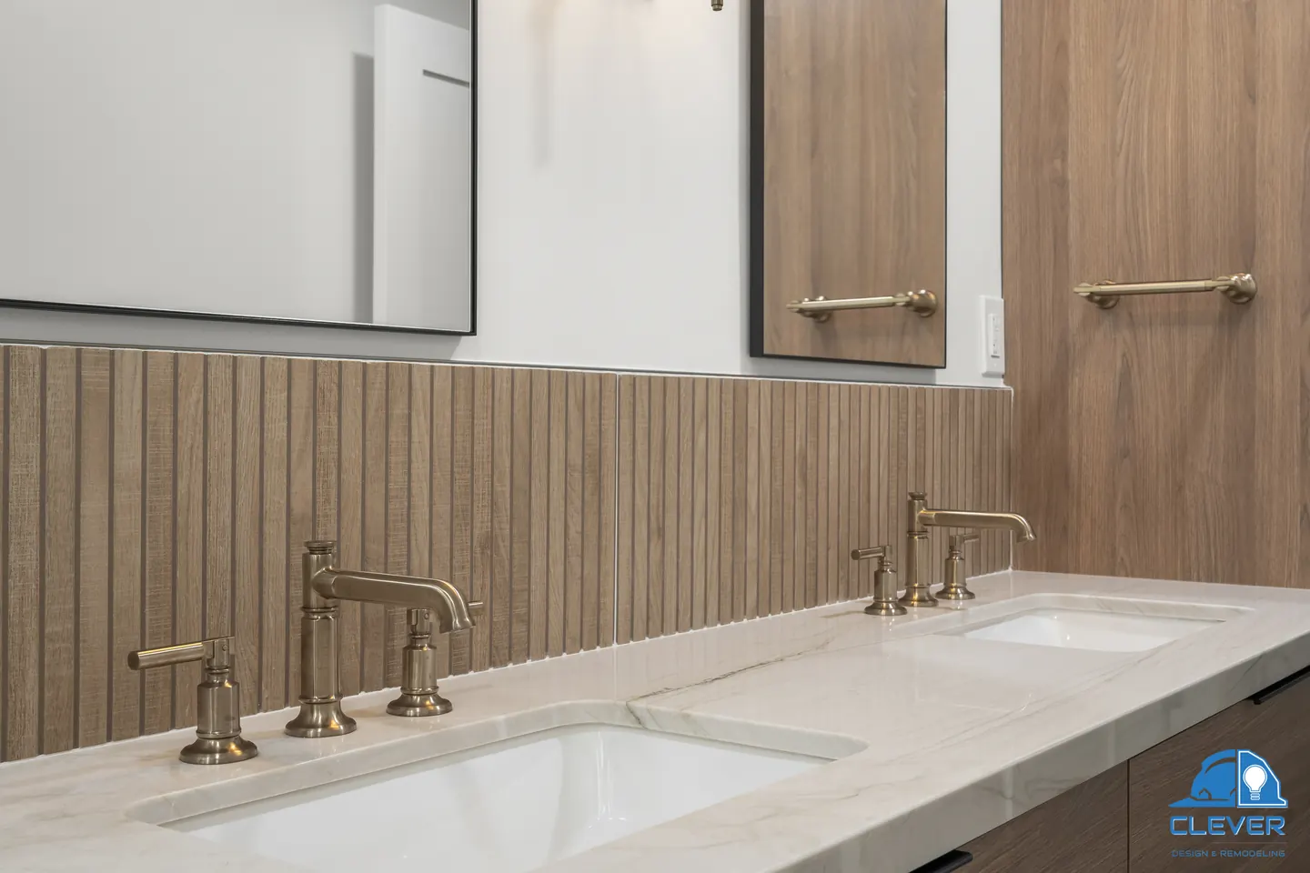 Brass bridge faucets on a stone vanity top against fluted wood-look tile, kitchen and bath remodel in Los Gatos, CA