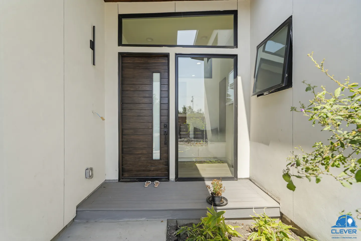 Wood front door with a vertical glass lite, a glass sidelight and a black awning window, modern home in Santa Clara, CA