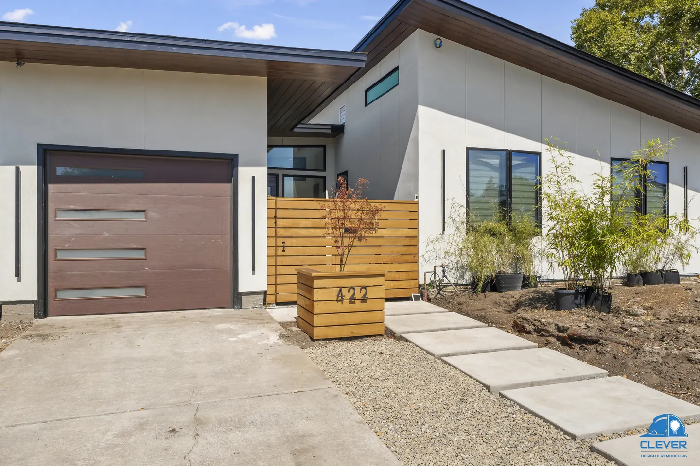 Front of a modern single-story home with white stucco, a brown garage door and a horizontal cedar fence, modern home in Sunnyvale, CA