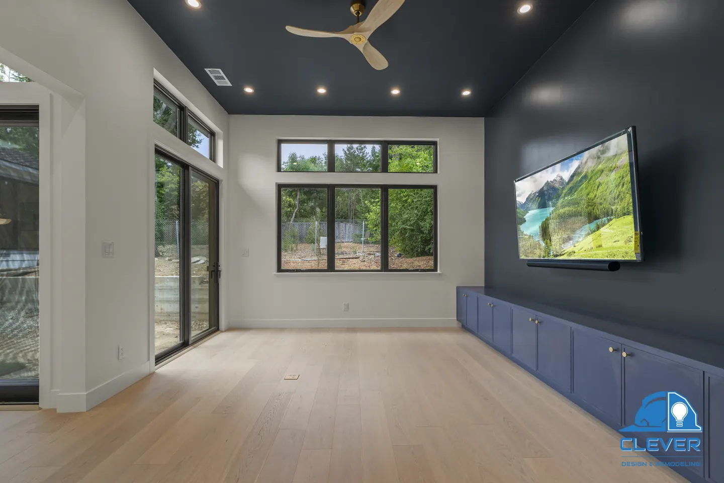 Media room with a navy ceiling and accent wall, built-in navy cabinets and black-framed sliding doors, whole-home remodel in Palo Alto, CA