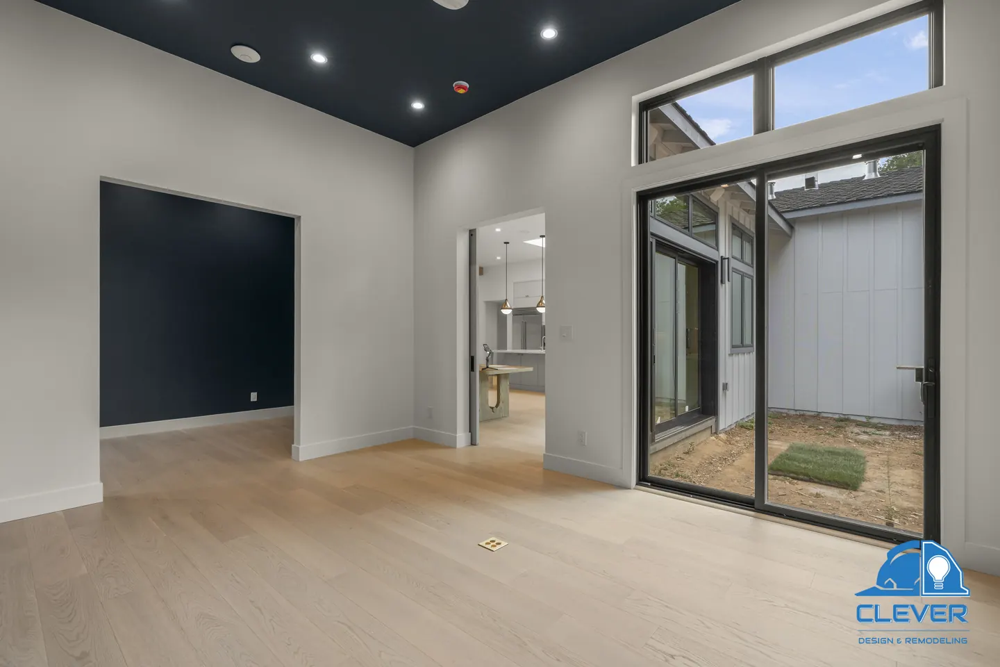 Navy-ceilinged room with transom windows and black-framed sliding doors to a side courtyard, whole-home remodel in Saratoga, CA